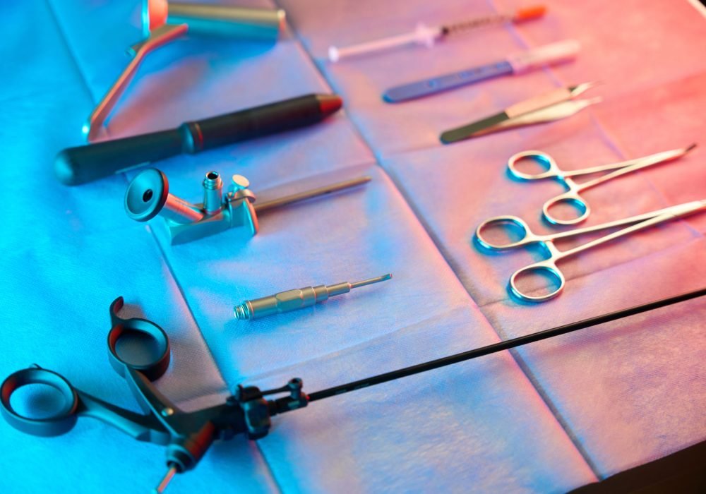 Closeup of rectal biopsy forceps arranged on table next to anoscopes and stainless steel scissors